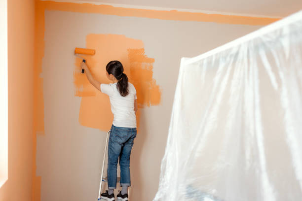 View of Woman Painting New Apartment. Renovation, Repair and Redecoration Concept.